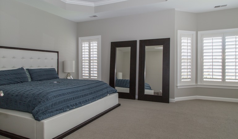 Polywood plantation shutters work well with minimalist design. White shutters in a minimalist bedroom in Fort Lauderdale.