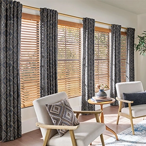 Navy blue print draperies over wooden blinds inside a large living room